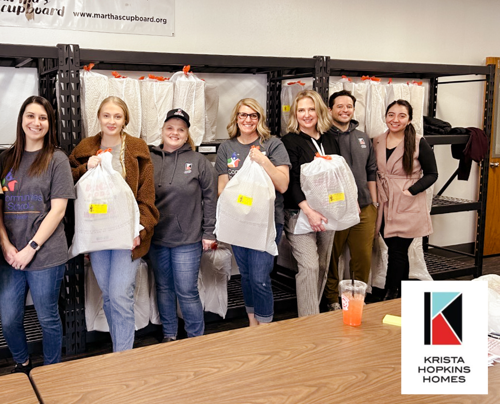Krista Hopkins Homes team standing proudly alongside Communities in Schools staff during a volunteer day, united in our commitment to empowering students and supporting the community.